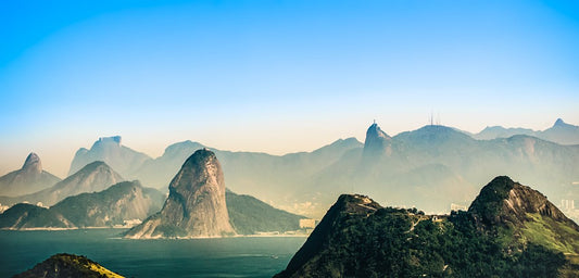 Global eSIM for travel; scenic view of foggy mountains with body of water in the foreground in Brazil.