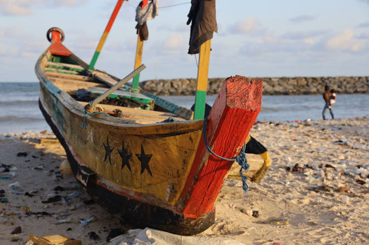 Travel SIM; photo of a traditional African canoe ashore on a sandt beach.