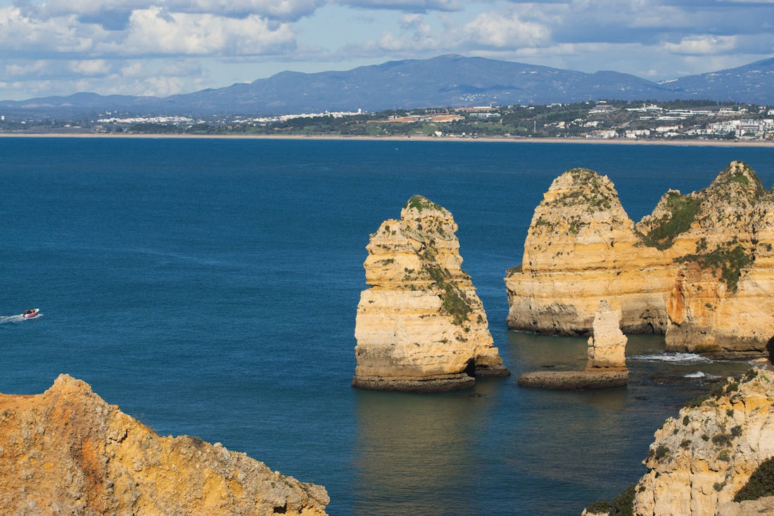 Best eSIM Portugal; scenic ocean view in Portugal showing rocky coastline with mountains in the background