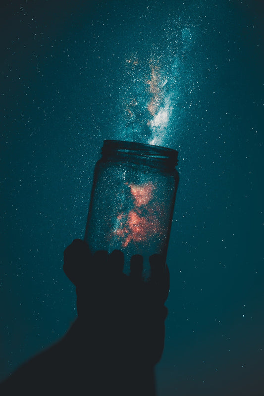 Clear glass jar against the stars in the night sky as seen by a young traveler