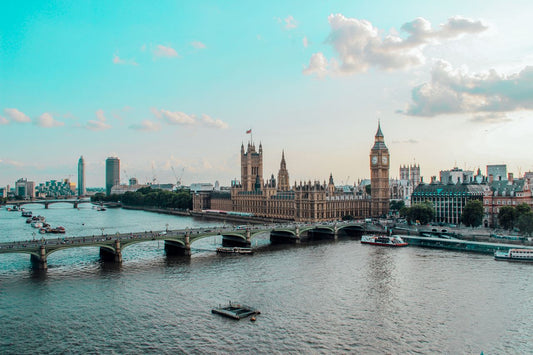 UK travel eSIM; photo of the skyline of London, UK, with the Thames River in the foreground and the House of Parliament in the background.