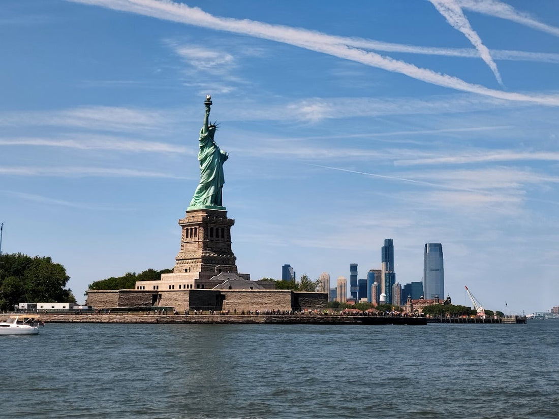 Unlimited Data eSIM USA; a photo of the Statue of Libert in the USA with water in the foreground and a blue sky overhead