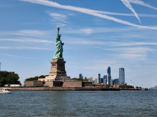 Unlimited Data eSIM USA; a photo of the Statue of Libert in the USA with water in the foreground and a blue sky overhead