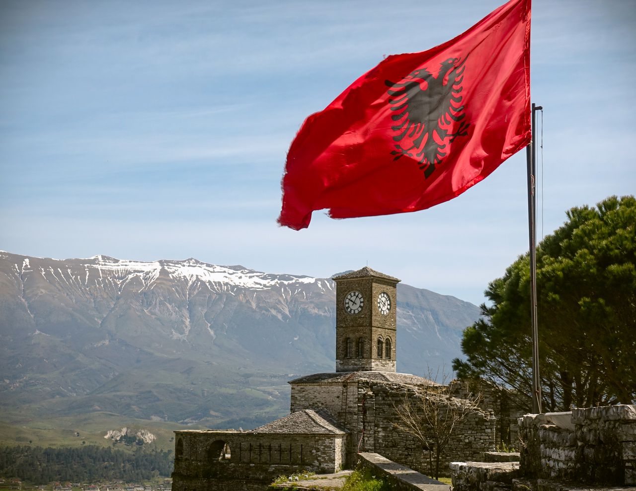 Best Albania eSIM - photo of a mountain scene in Albania with the Albanian flag in the foreground