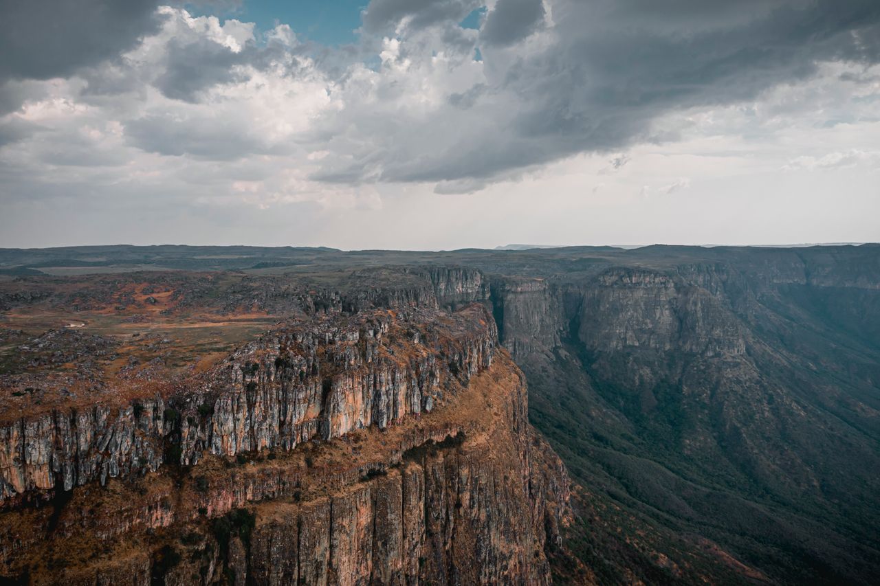 Best Angola eSIM for travel; a deep canyon with steep rocky cliffs in Angola, dry brown vegetation, and a cloudy sky overhead.