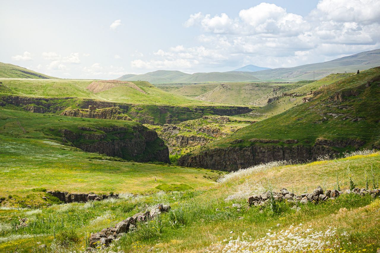 Best Armenia eSIM for travel; photo of a scenic landscape of a deep green valley with steep rocky cliffs, rolling hills in Armenia.