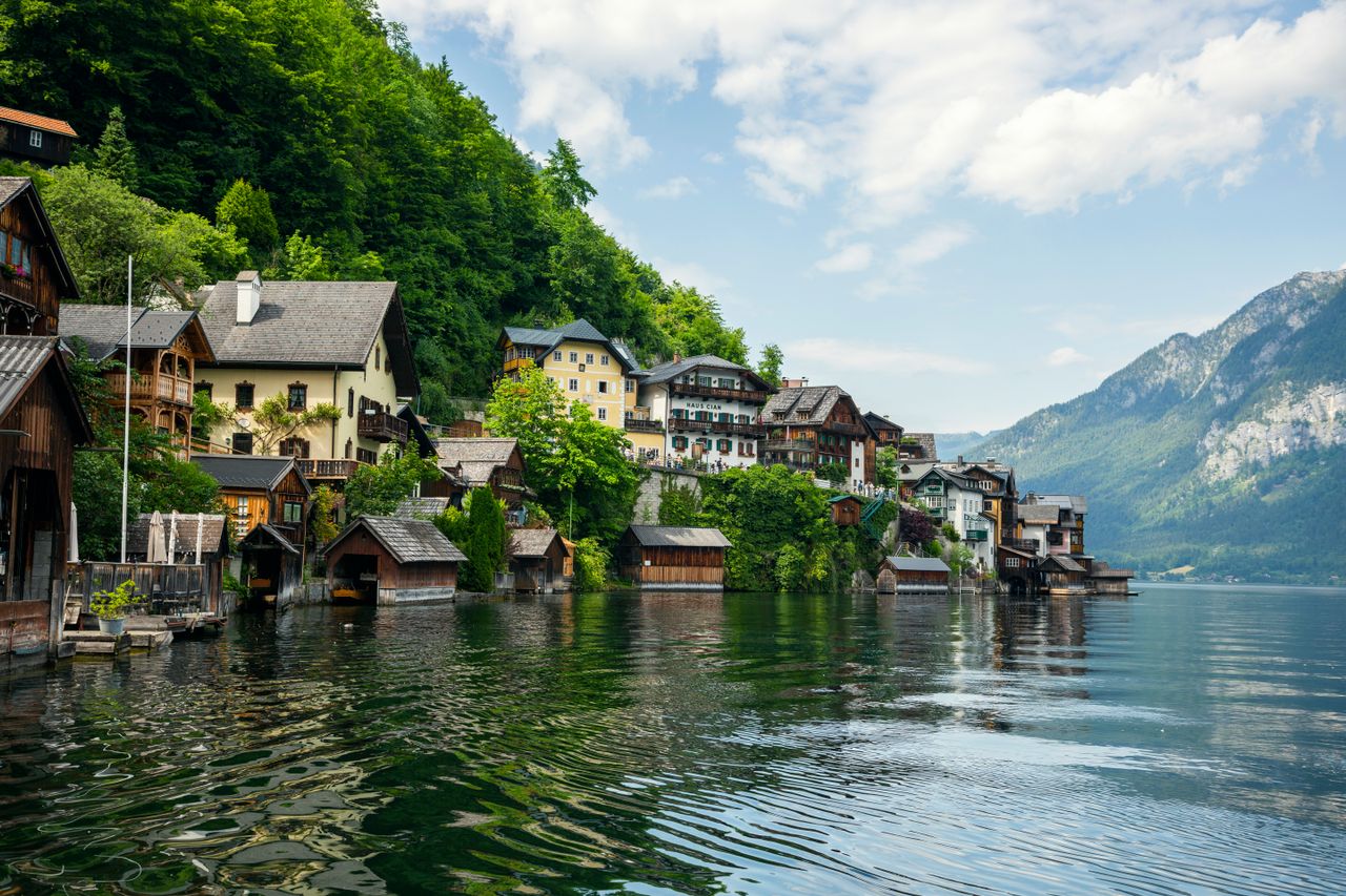 Best eSIM Austria for travel - hoto of Austrian village along a lakeside with mountains in the background.