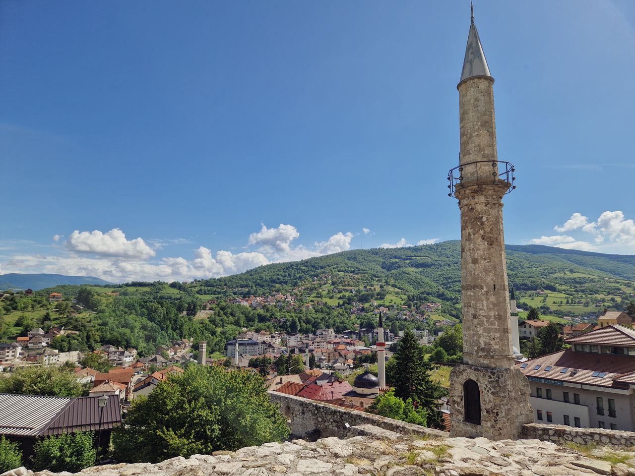 Balkans eSIM plans for travel - photo of a Minaret with a cityscape and mountains in the background