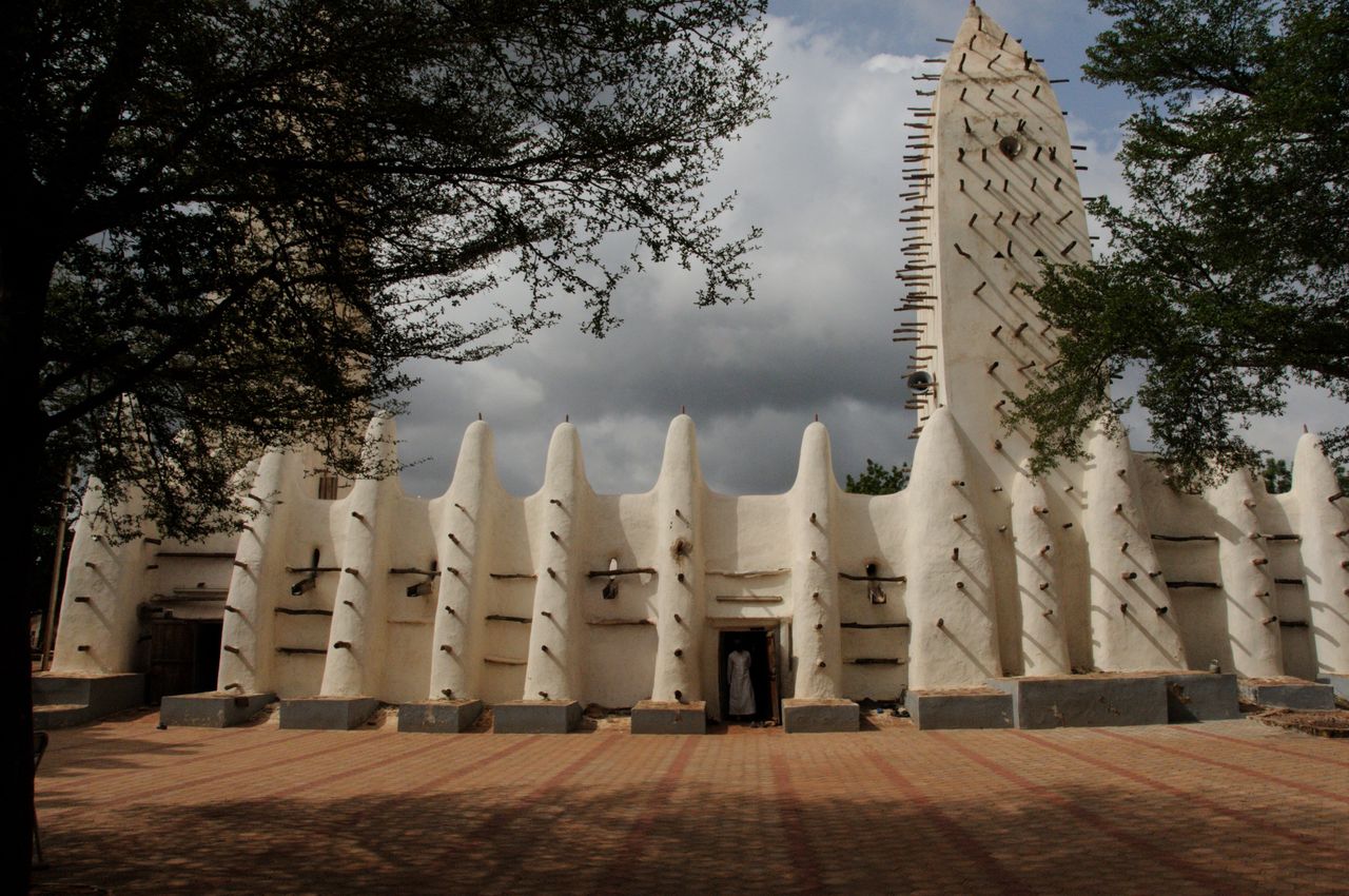 Best eSIM for Burkina Faso: a traditional white stucco mosque in Burkina Faso with tall spires and carved geometric details.