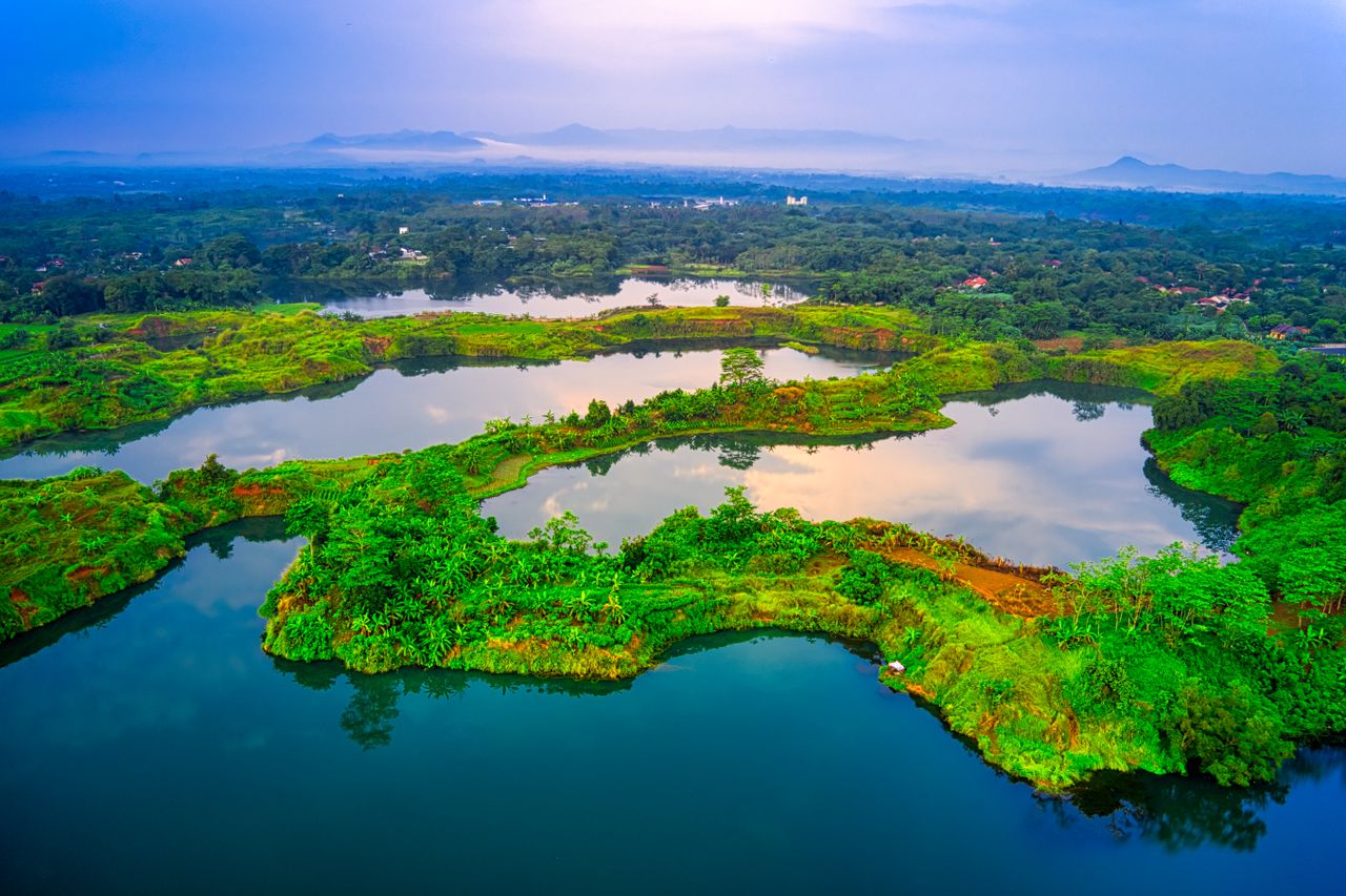Best DRC eSIM for travel; aerial view of a lush green landscape in the DRC with winding lakes reflecting the sky, surrounded by dense vegetation.