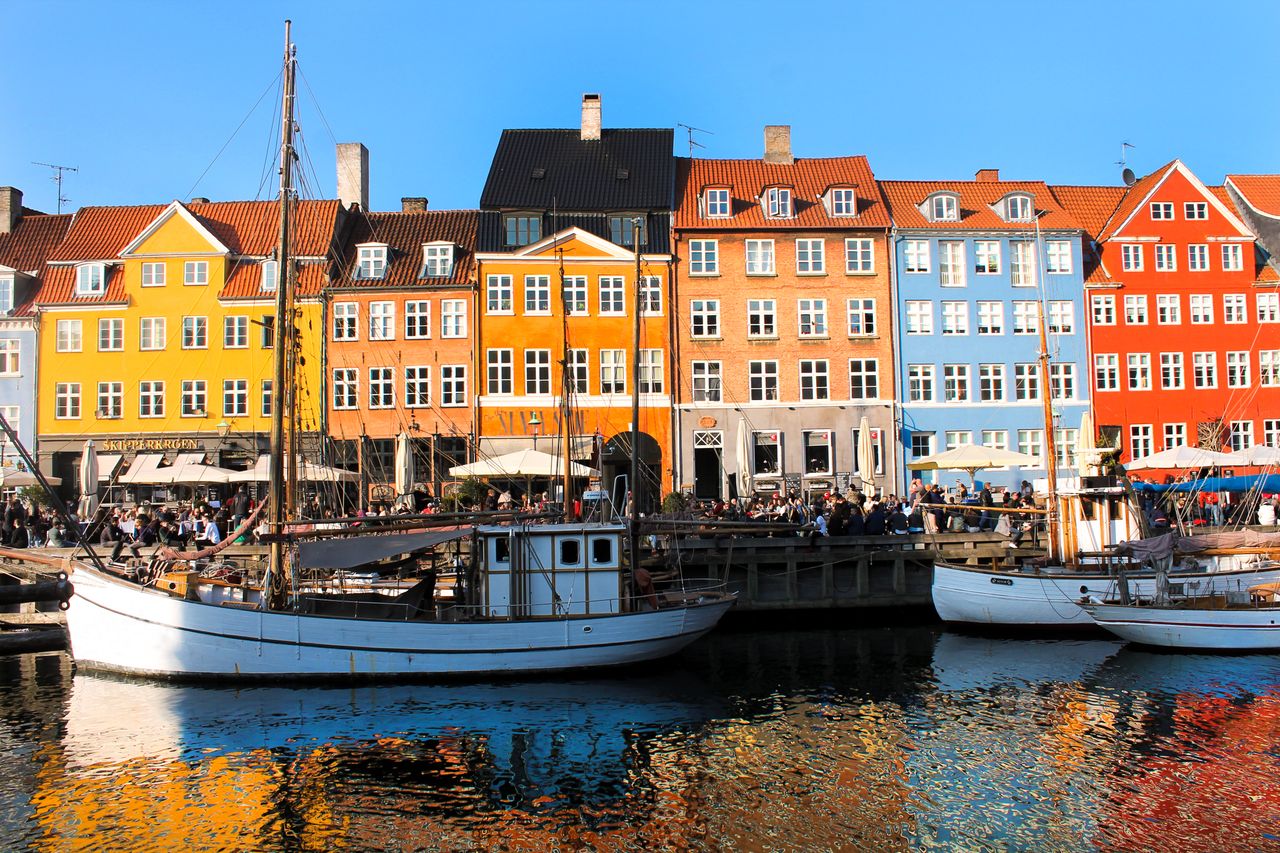 Best eSIM for Denmark - photo of colorful buildings along a waterfront with boats in Copenhagen, Denmark.