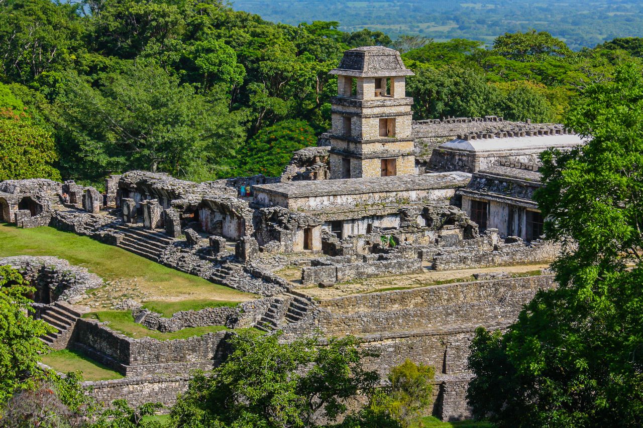 Best Honduras eSIM for travel; photo of a Mayan ruins in Honduras with a tall central tower and stone structures surrounded by dense green forest.