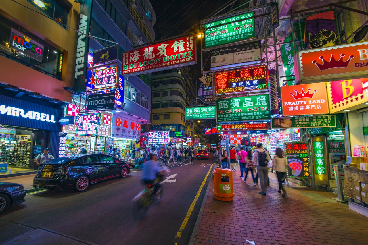 Best Hong Kong eSIM for travel; a vibrant street scene in Hong Kong with neon signs and people in a city at night.