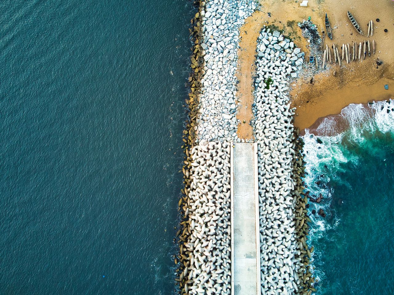 Best Cote d'Ivoire eSIM for travel; a aerial photograph of a causeway along the ocean in Ivory Coast.