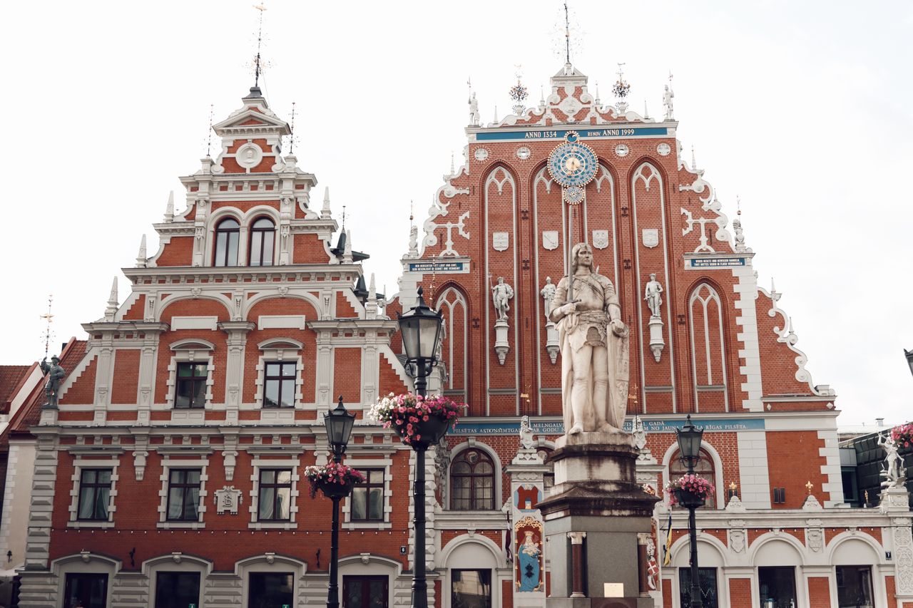 Best eSIM for Lithuania - A scenic photograph of the historic Red Square Town Hall in Riga, Latvia, featuring its distinctive red brick and white facade.