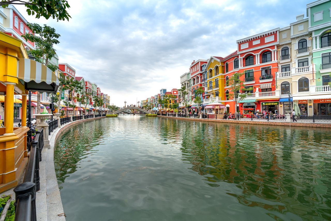 Best eSIM for Macau: a canal view in Macau with colorful colonial-style buildings lining both sides, reflections in the water.