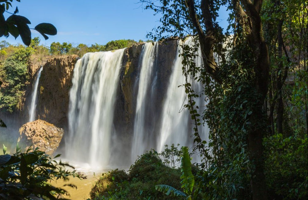 Best Madagascar eSIM for travel; a scenic view of a large waterfall cascading over a rocky cliff in Madagascar.