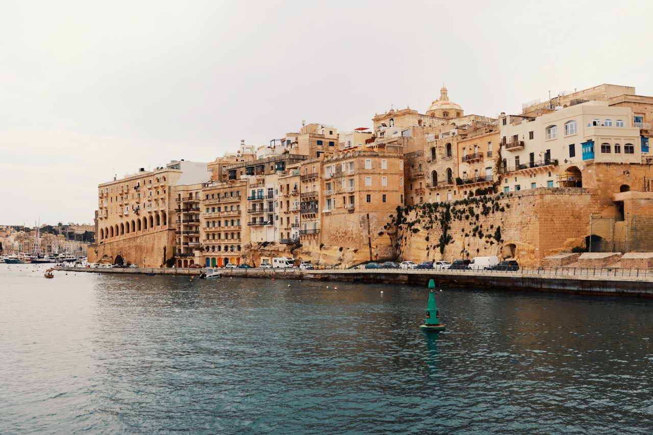 Best eSIM for Malta travel - photo of city in Malta with sea in the foreground.