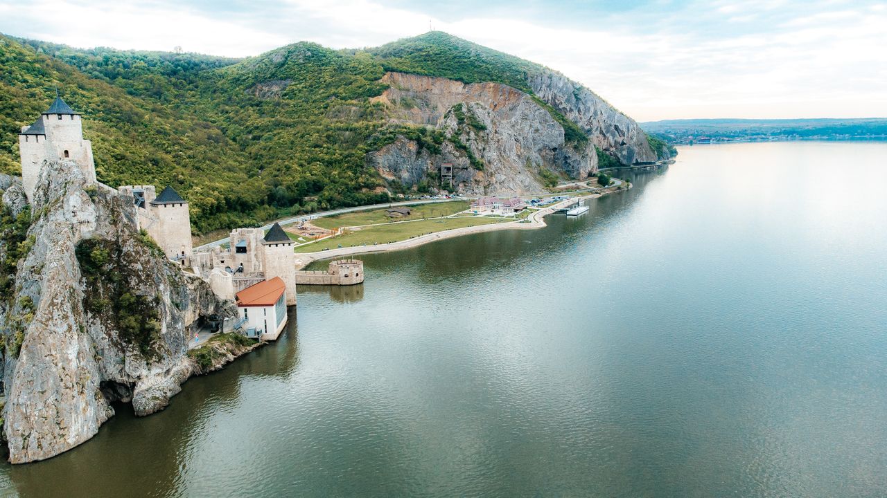 Best Moldova eSIM for travel; photo of a scenic lake in Moldova with historic castle perched on the cliffs above the lake.
