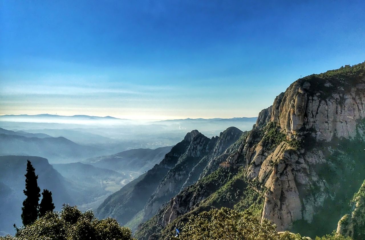 Best eSIM for Montserrat travel; a mountain landscape in Montserrat with steep rocky cliffs, green vegetation, and a hazy valley in the distance.