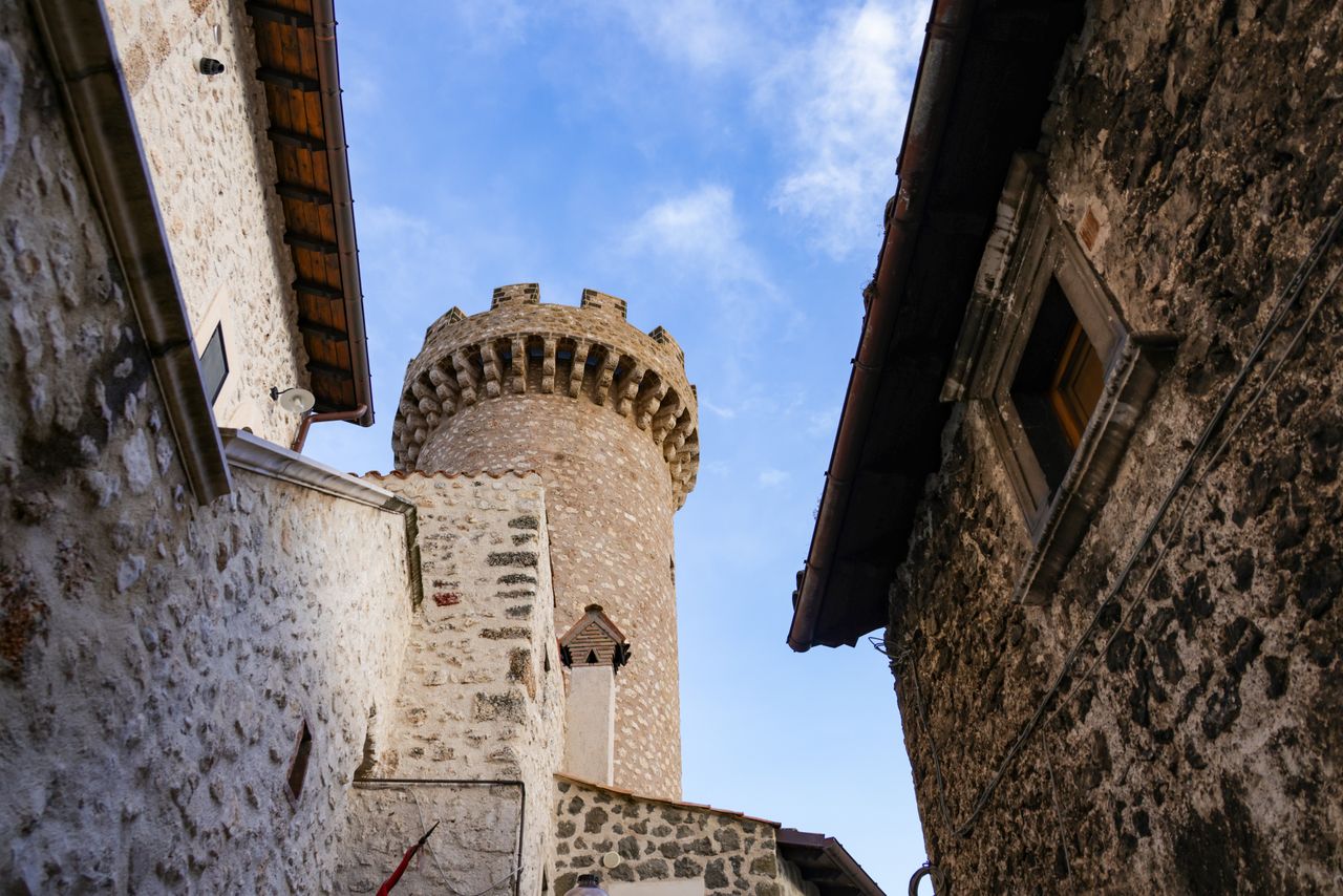 Best San Marino eSIM for travel; a low-angle view looking up at a stone tower between two historic buildings in San Marino.
