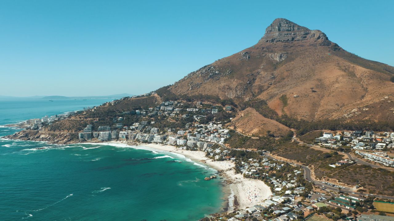 Best South Africa eSIM - photo of South Africa beach town with mountain in the background and ocean in the foreground.