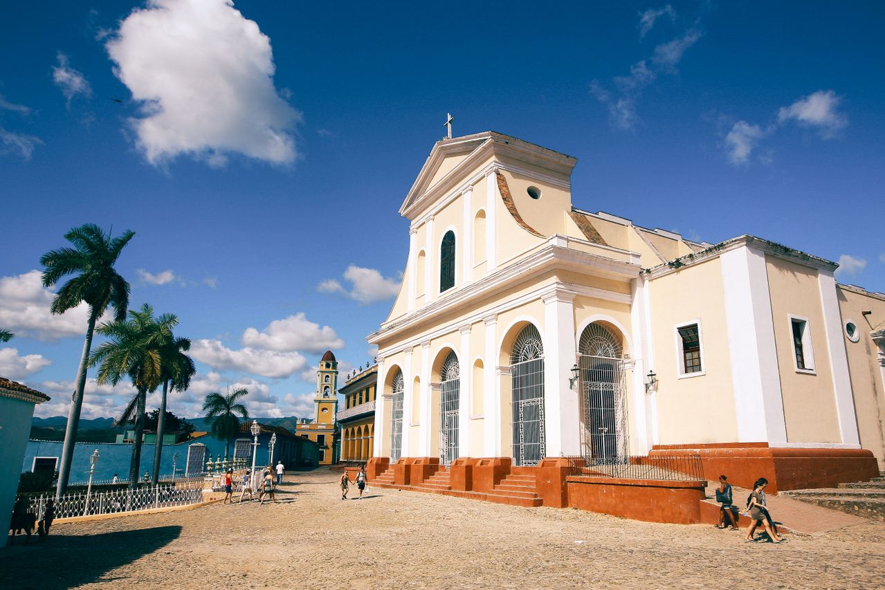 Best Trinidad and Tobago eSIM for travel; a large cream-colored historic church in Trinidad and Tobago with arched windows and a central dome, set in a sandy plaza.