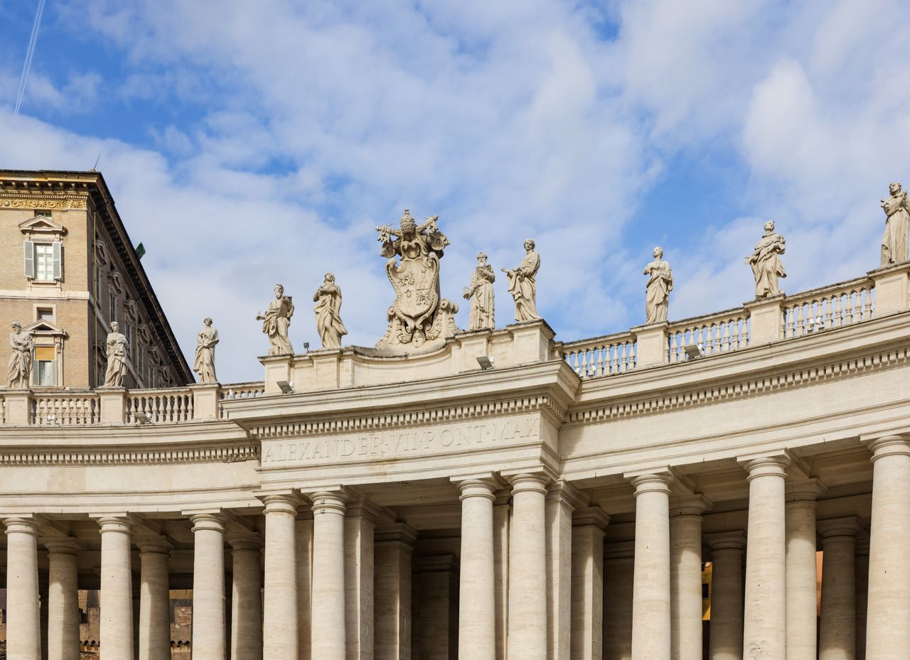 Best Vatican City eSIM for travel; the grand colonnade of St. Peter's Basilica in Vatican City, featuring numerous classical stone statues and columns.